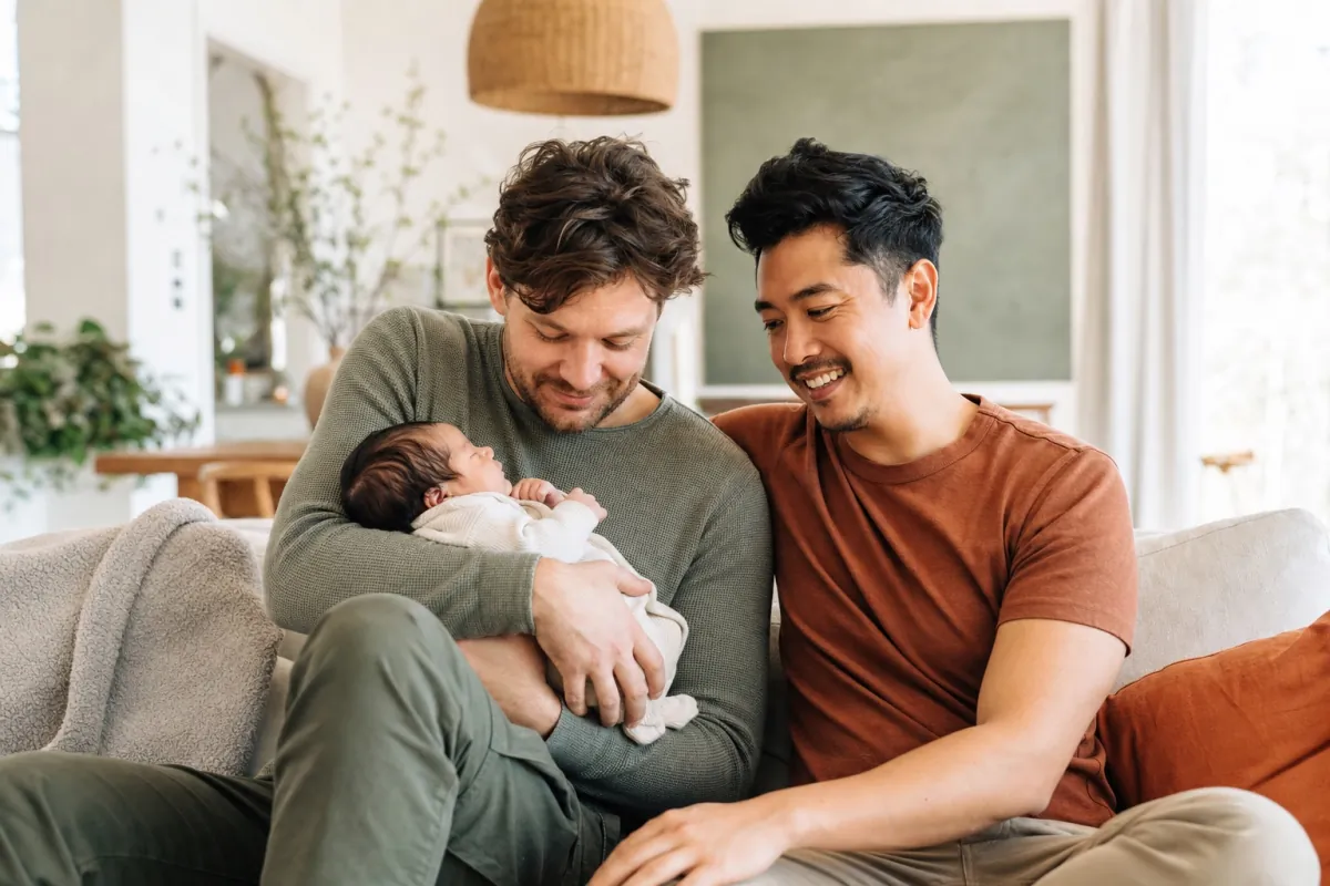 Dos padres sosteniendo a su bebé en casa